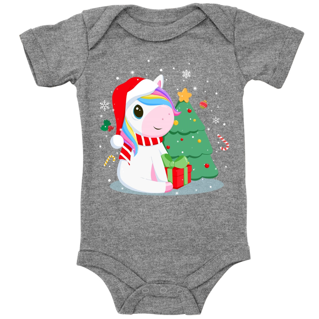 Einhorn sitzt am Tannenbaum und freut sich über ein Geschenk